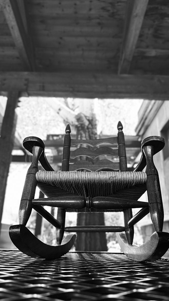 Black-and-white photograph of a rocking chair viewed from the front.
